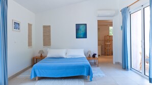 A bedroom with a bed, nightstands, a window with curtains, and a door leading to a balcony. - 3 bedroom house near Santa Giulia beach Residence heated swimming pool (Porto-Vecchio)