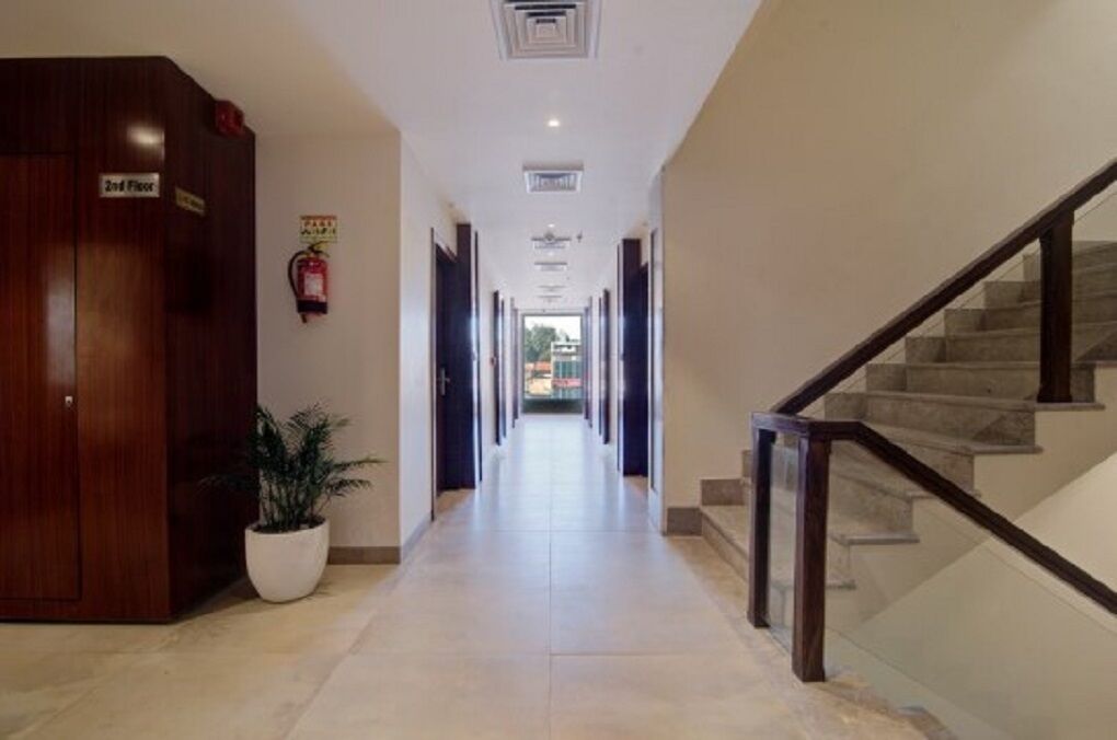 A hotel corridor with a wooden wardrobe labeled '2nd Floor' and a potted plant.