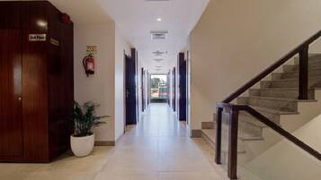 A hotel corridor with a wooden wardrobe labeled '2nd Floor' and a potted plant.