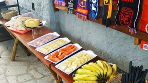 Una mesa de buffet con diversos alimentos y un cesto de utensilios.