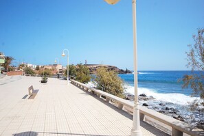 A paved walkway with street lamps, overlooking a rocky coastline and the sea. - Cute little apartment close to promenade (Arinaga)