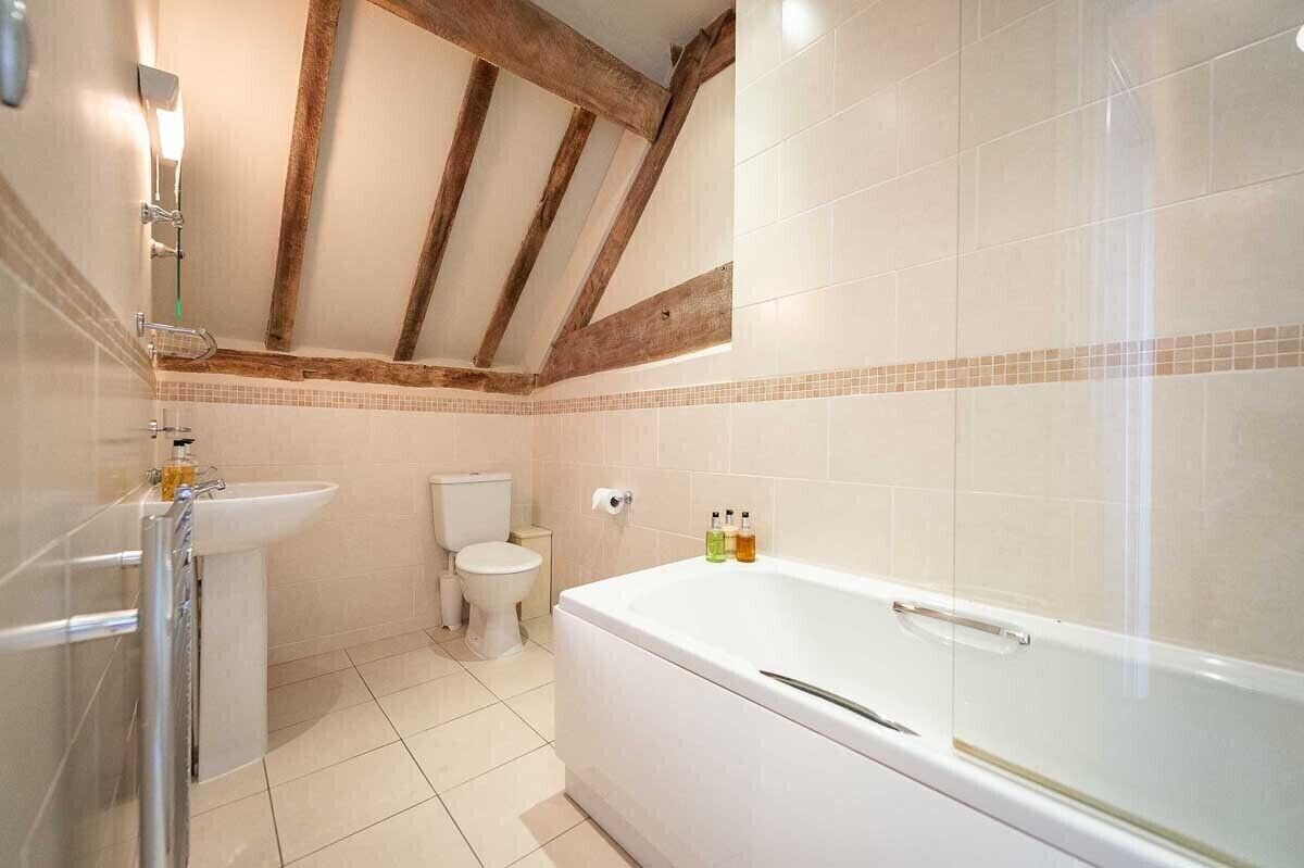 A bathroom with a bathtub, toilet, and sink.