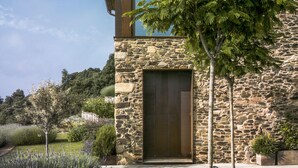 Un bâtiment moderne en pierre, doté d’une grande porte d’entrée et d’une petite fenêtre.