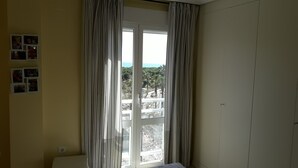 A room with a large sliding glass door leading to a balcony, a bed, and a wall with framed photos. - DUPLEX PENTHOUSE APARTMENT in Isla Cristina. (Isla Cristina)