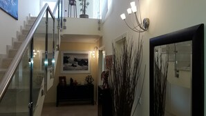 A modern interior with a staircase, a framed picture, a console table, and decorative branches. - DUPLEX PENTHOUSE APARTMENT in Isla Cristina. (Isla Cristina)