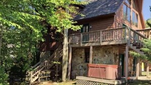 Eine rustikale Holzhütte mit Steinunterbau und einem Balkon.
