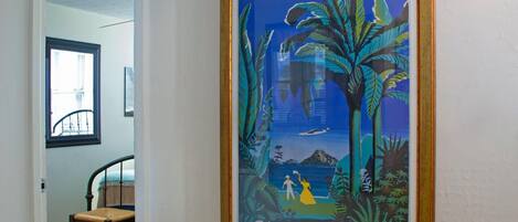 Un cartell de viatge emmarcat del Carib, amb un home i una dona a la platja, palmeres i un vaixell.