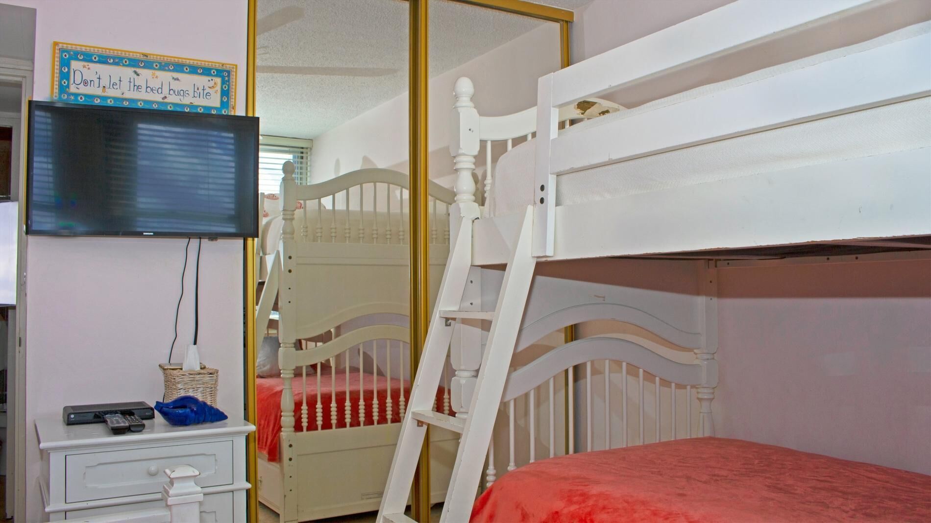 A child's bedroom with bunk beds, a television, and a dresser.