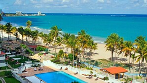 Resort com piscina, praia e vista para o oceano.