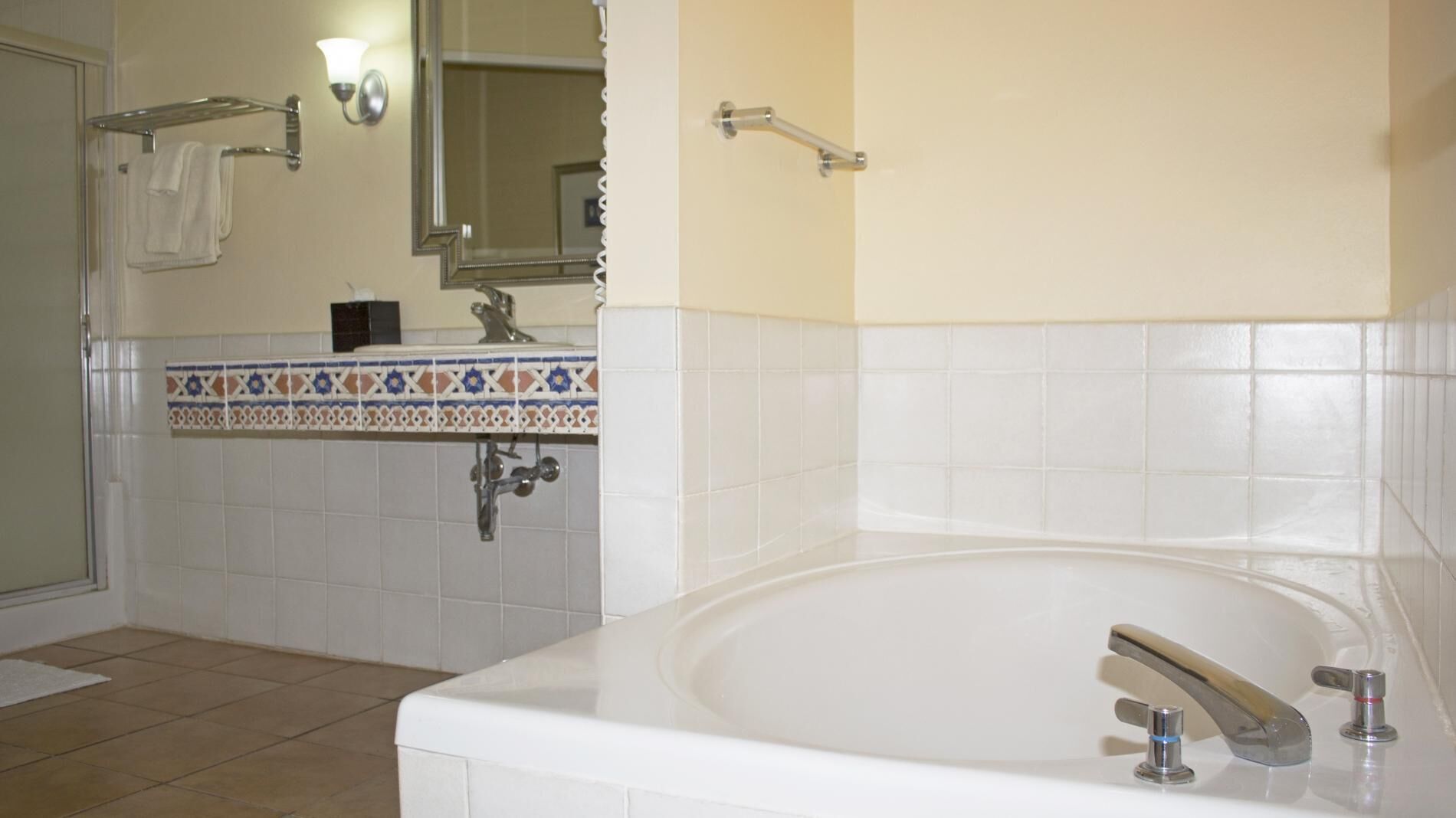 Ein Badezimmer mit einer weißen Badewanne, einem Waschbecken mit Spiegel darüber und einer Duschkabine.