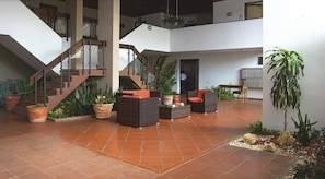 Stunning indoor space with a central staircase, potted plants, and cozy seating area.