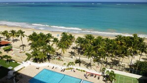 A beach with palm trees, a swimming pool, and a view of the ocean. - El Capitan (Carolina)