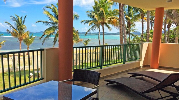 A balcony with a view of the ocean and palm trees. - Crystal Blue (Luquillo)