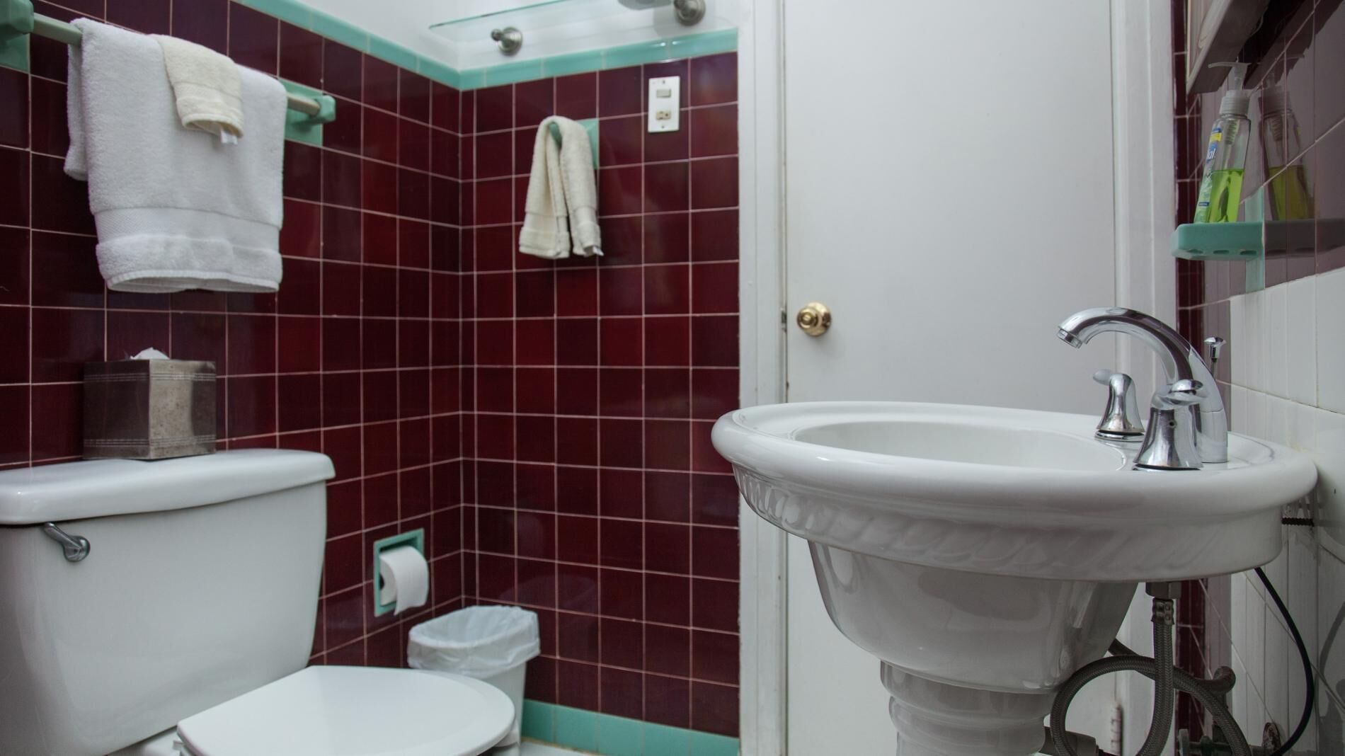 Une salle de bain avec un lavabo blanc, des toilettes et un espace douche.