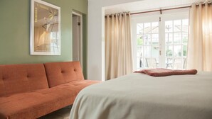 A room with a bed, a sofa, a window with curtains, and a poster on the wall. - Villa Verde (San Juan)