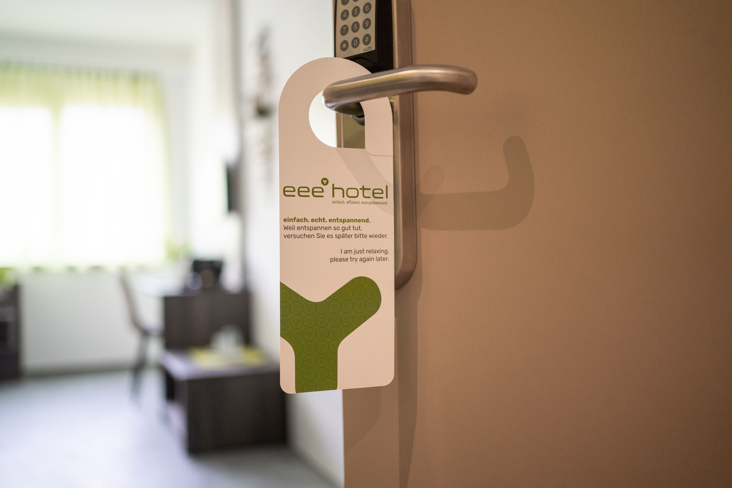 A hotel room door with a keycard holder displaying the hotel's name and a message.