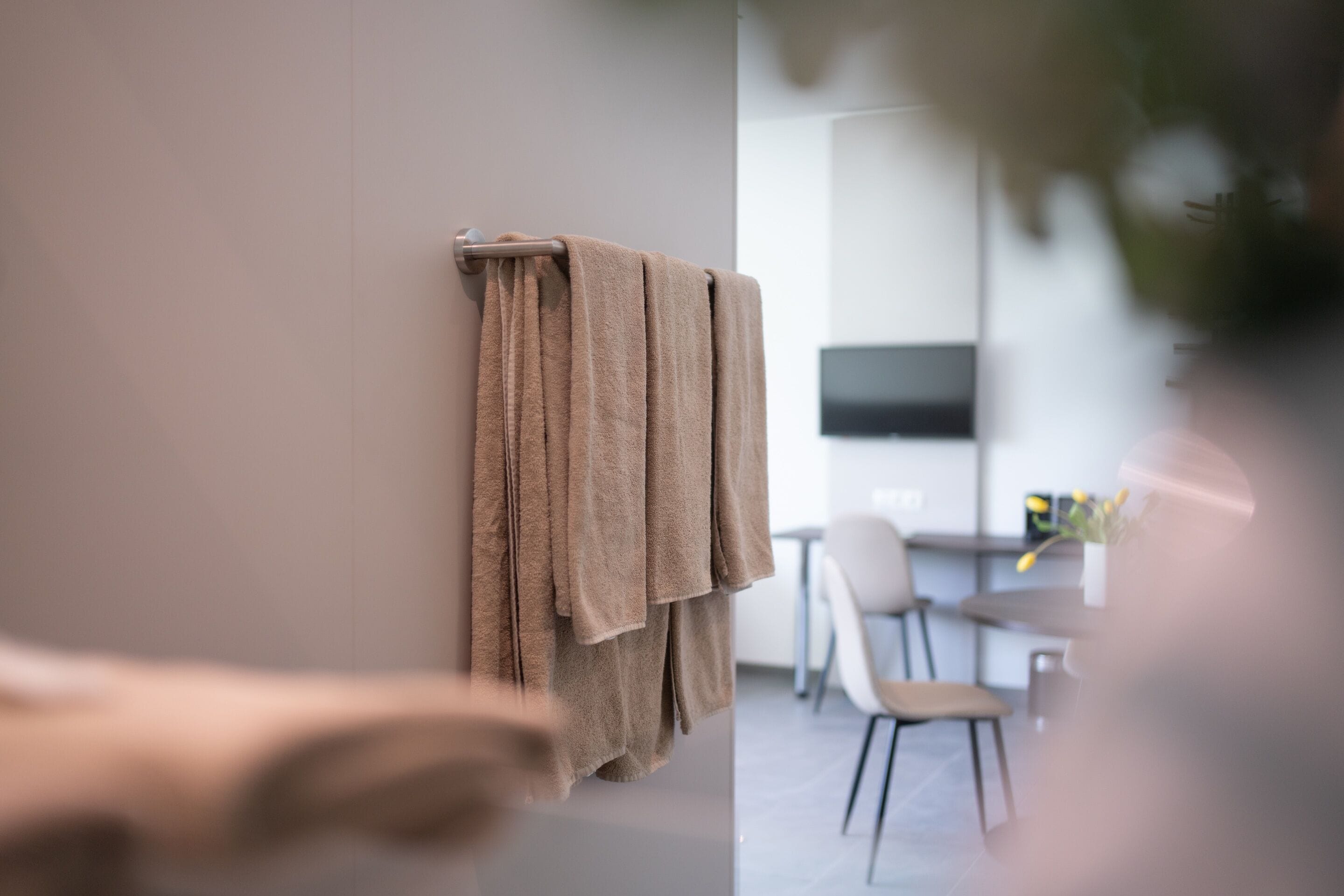 A modern bathroom with a towel rack holding multiple towels.