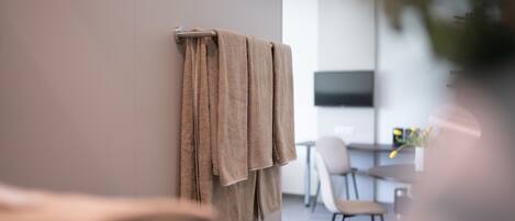 A modern bathroom with a towel rack holding multiple towels.