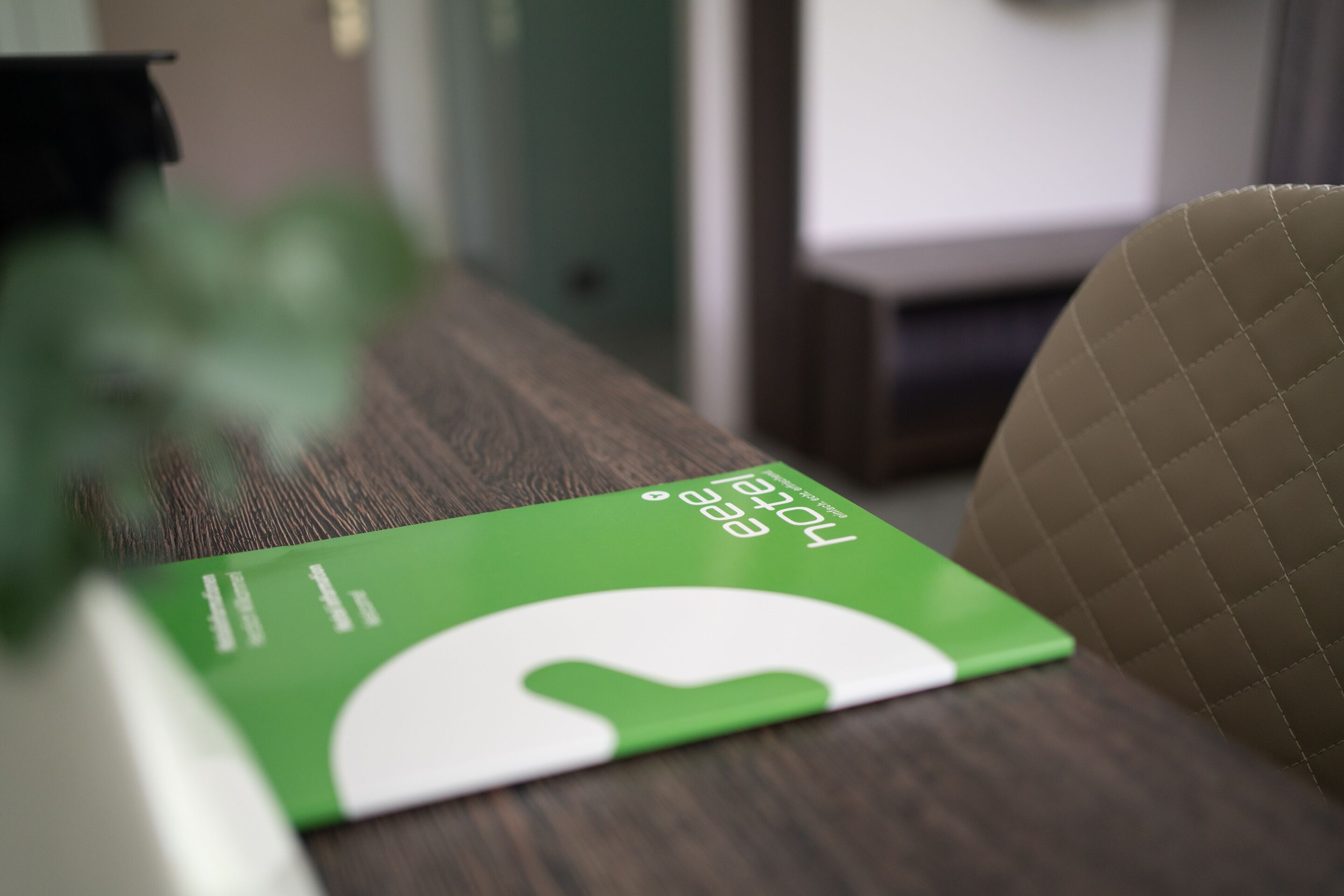 Una carpeta verde con texto blanco sobre una mesa de madera.