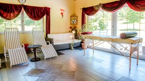 A room with a sofa, two striped chairs, a small table, a bench, and a large window with curtains. - Tameggerhof (Gurk)