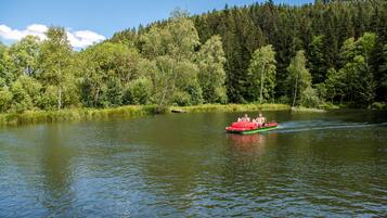 Un bote en un río tranquilo rodeado de bosque denso.