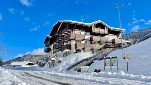 A multi-story hotel with balconies, a ski lift, and a snowy mountain backdrop. - Ski-in/ski-out apartment with terrace, pet-friendly, Flumet (Flumet)
