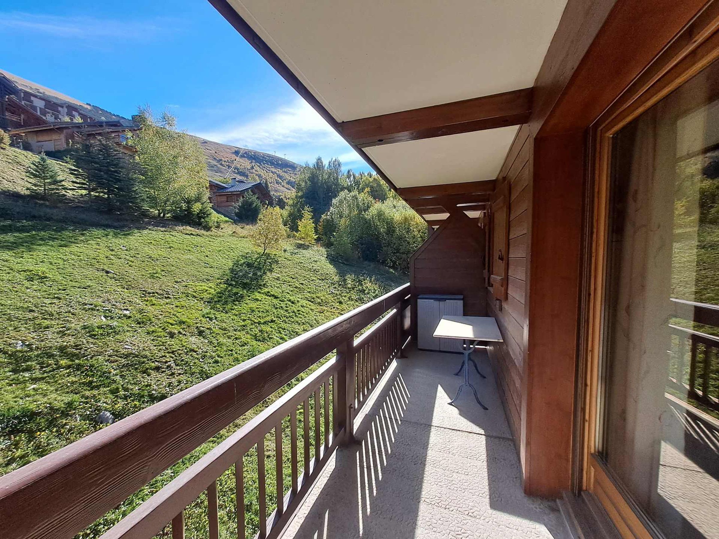 A balcony with a view of a green landscape and a building in the distance.