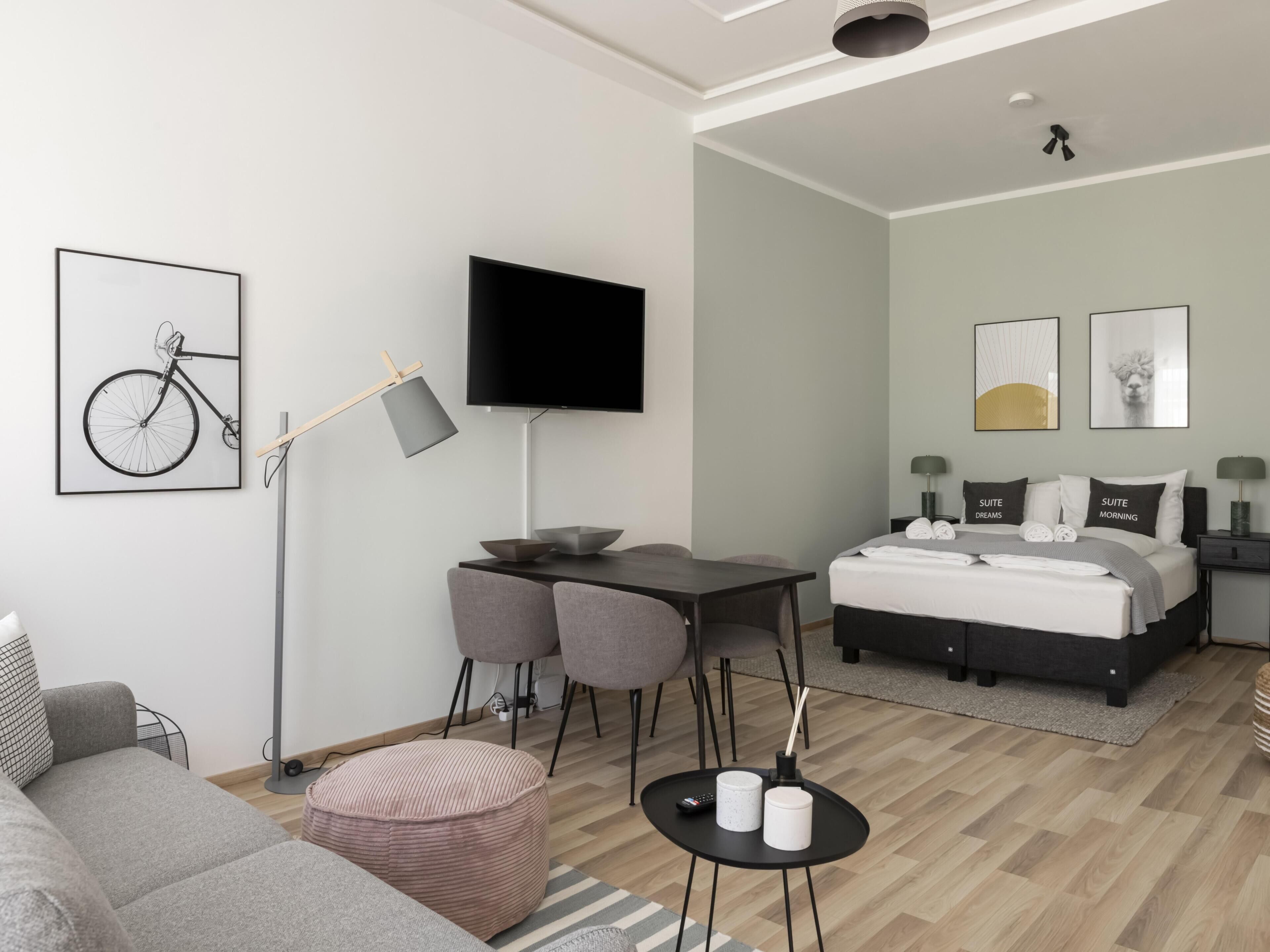 Une chambre d’hôtel moderne équipée d’un lit, d’un bureau et d’un coin salon.