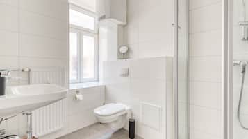 A modern bathroom with a sink, toilet, and shower.