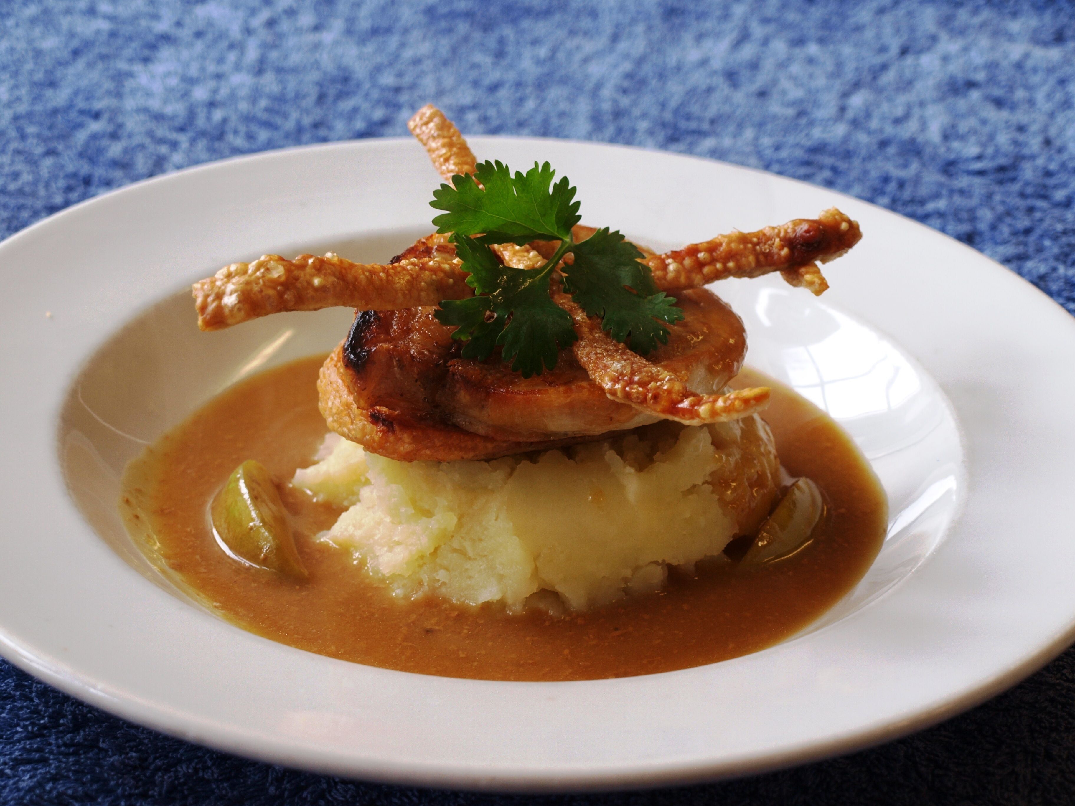A plate of food with mashed potatoes, gravy, and a garnish of parsley.
