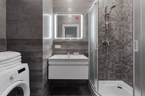 Studio | Badkamer | Een douche, een haardroger, pantoffels, handdoeken