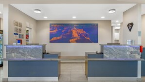 A reception area with marble counters, a large canyon mural, and a sign indicating breakfast availability. - Best Western Plus Executive Residency Phoenix North Happy Valley (Phoenix)