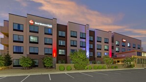 A hotel with multiple floors, a parking lot, and a landscaped area with trees. - Best Western Plus Executive Residency Phoenix North Happy Valley (Phoenix)