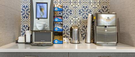 Un espace dédié au café, comprenant une machine à café, un chauffe-tasse et un distributeur de café.