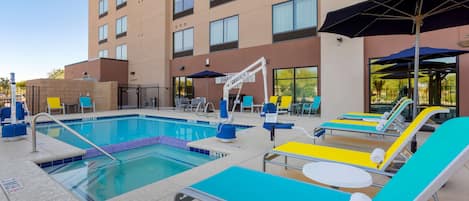 Una piscina al aire libre, sillones reclinables de piscina