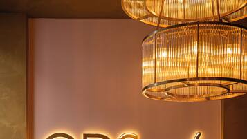 A hotel sign with the name "ODSweet Duomo Milano Hotel" and a tufted leather sofa with cushions.