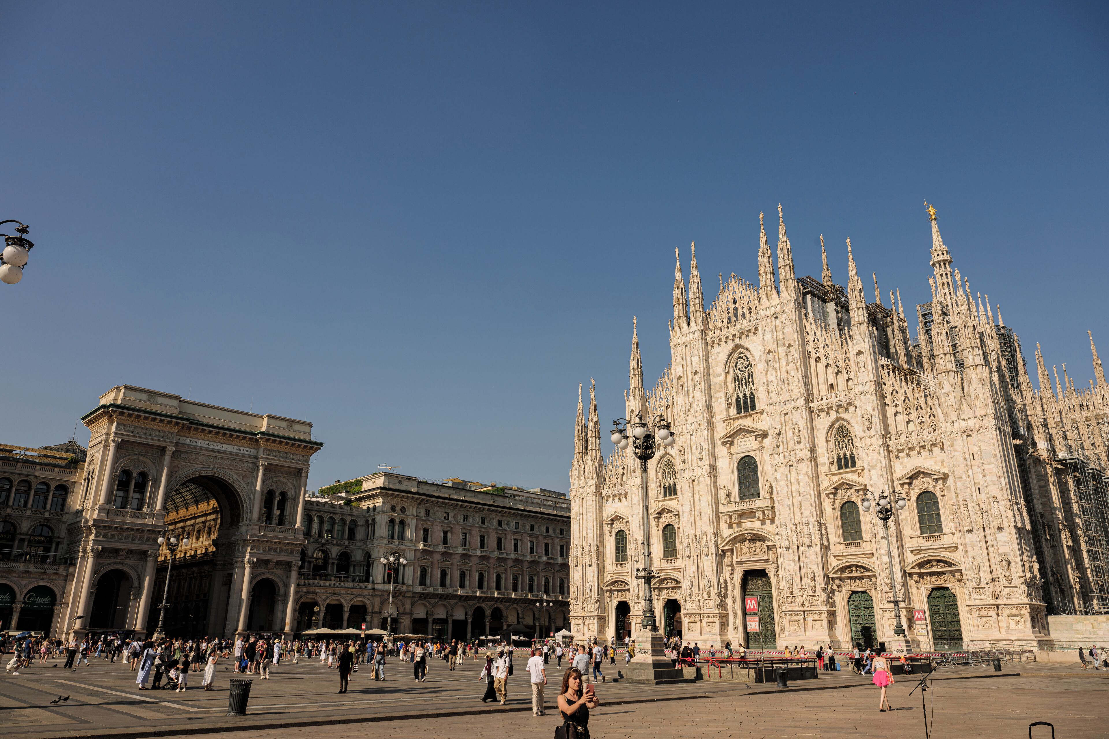 A historic square with a grand cathedral and an ornate archway.
