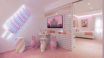 A modern, pink-themed room with a flat-screen TV, decorative bunny stools, and a unique wall-mounted light fixture.