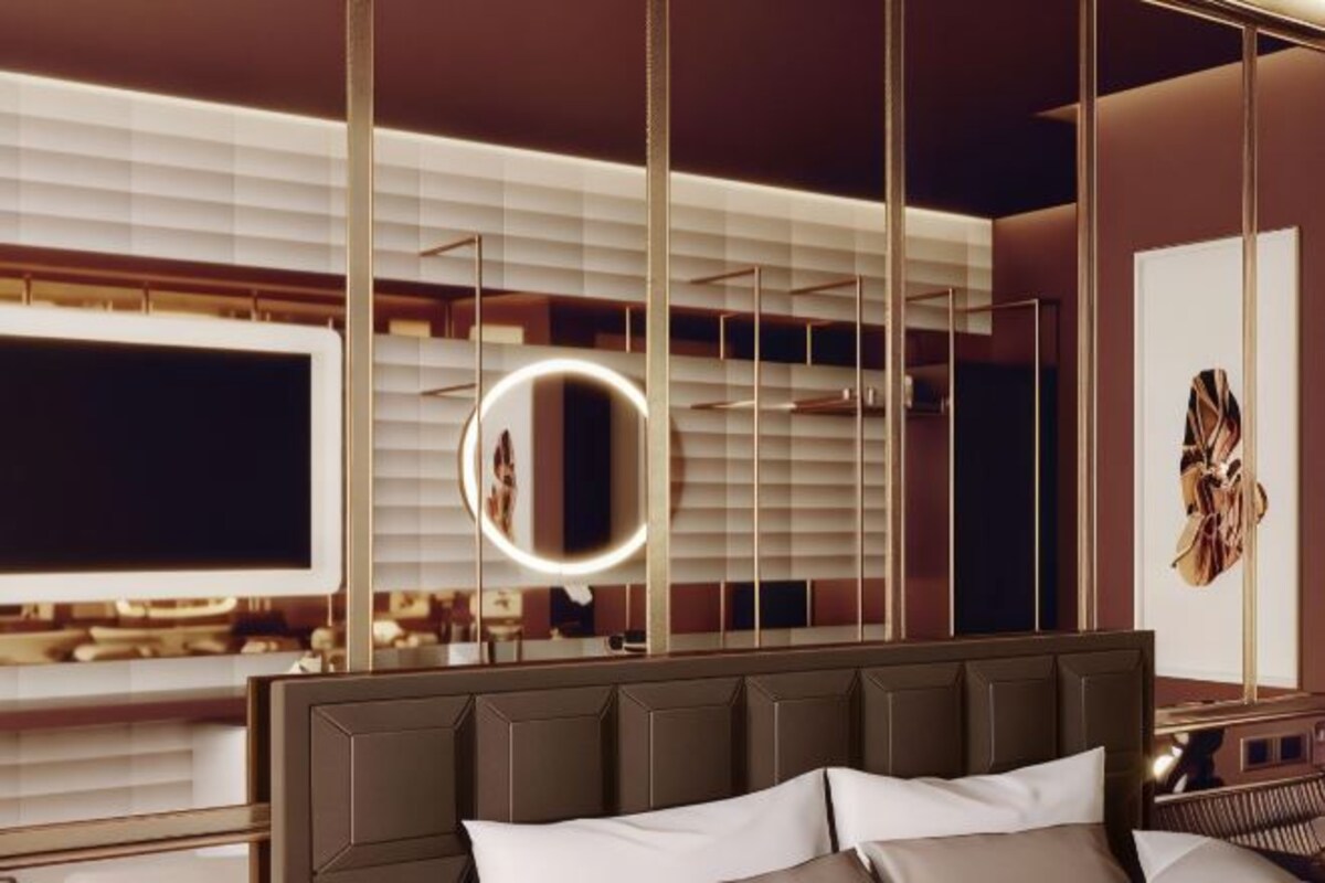 Une chambre d’hôtel moderne avec un grand lit, une coiffeuse avec un miroir et une grande fenêtre équipée de stores.