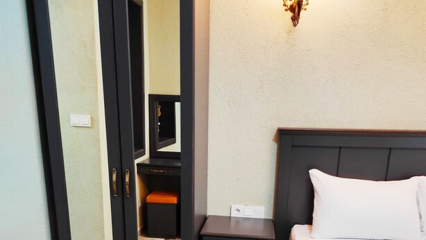 A hotel room with a bed, bedside table, and a wardrobe. - Lebon Hotel Old City (Istanbul)