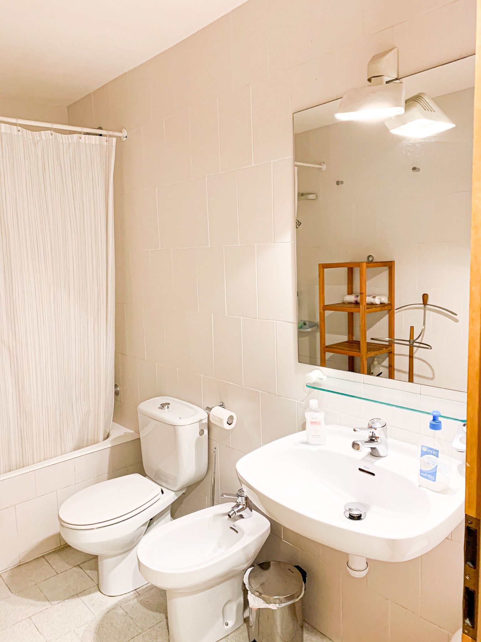 Une salle de bain équipée de toilettes, d’un bidet, d’un lavabo et d’un miroir.