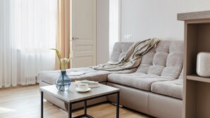 Un salon moderne avec un canapé, une table basse et un vase rempli de fleurs.