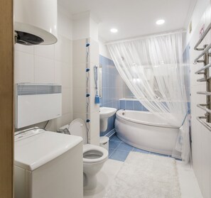 A modern bathroom with a toilet, sink, and bathtub.