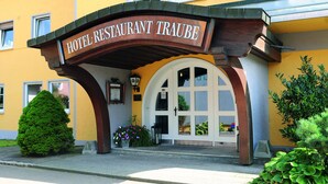 Ein Hotel Eingang mit einem Schild, auf dem 'HOTEL RESTAURANT TRAUBE' steht.