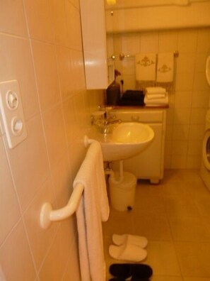 A bathroom with a sink, mirror, and towel rack. - Le Jardin Fleuri (Ollon)