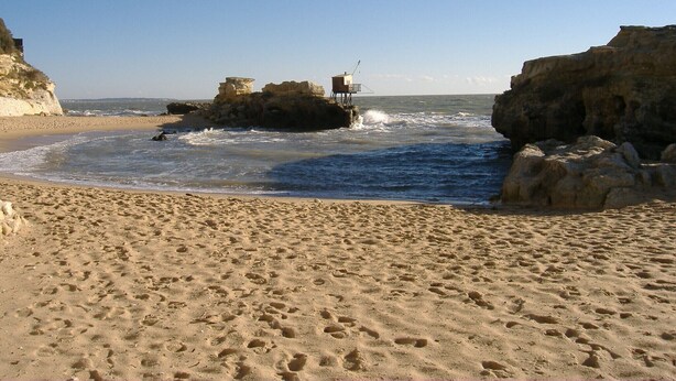 A sandy beach with rocky formations and a lifeguard tower. - Charming T2 house in a quiet condominium near the beaches. (Vaux-sur-Mer)