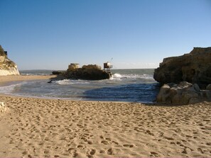 A sandy beach with rocky formations and a lifeguard tower. - Charming T2 house in a quiet condominium near the beaches. (Vaux-sur-Mer)