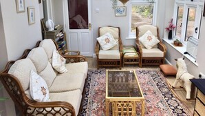 A cozy room with a sofa, two armchairs, a coffee table, and a hanging plant. - Bron Hafren (Montgomery)