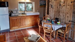 Una cucina accogliente con mobili in legno, un frigorifero bianco e un'area pranzo con un tavolo apparecchiato per due.
