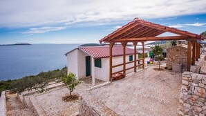 A coastal property with a stone wall, a small building with a red roof, and a wooden pergola overlooking the sea. - Small robinson house with pool (Vinišce)
